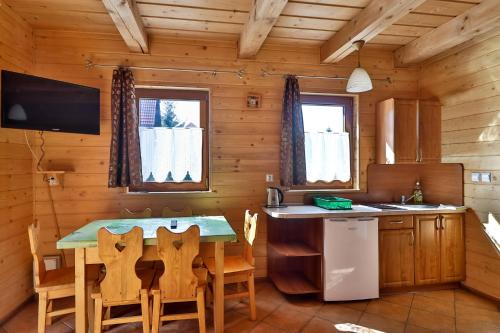 a kitchen with a table and chairs in a cabin at Domki w Istebnej in Istebna