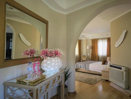 a bedroom with a bed and a vase of flowers on a table at Villa Moments - Guest House in Portimão