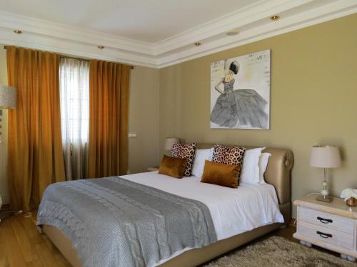 a bedroom with a large bed and a large window at Villa Moments - Guest House in Portimão