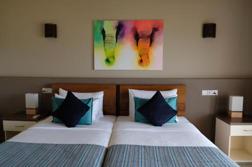 a bedroom with two beds and a painting on the wall at Twenty-Two Weligambay in Weligama