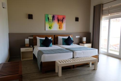 a bedroom with two beds and a bench in it at Twenty-Two Weligambay in Weligama