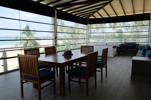 a dining room with a table and chairs at Twenty-Two Weligambay in Weligama