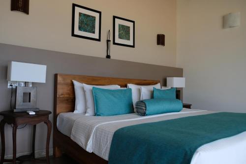 a bedroom with a large bed with blue pillows at Twenty-Two Weligambay in Weligama