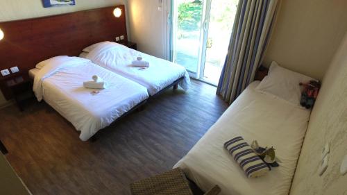 a hotel room with two beds and a window at VVF Golfe de Saint-Tropez in Sainte-Maxime
