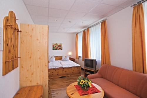 a living room with a couch and a bed at Landhaus Bergidyll in Bärenstein