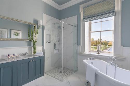 a bathroom with a tub and a shower and a sink at The Johnstown Estate in Enfield