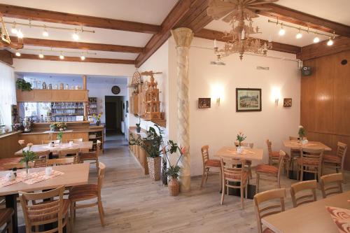 a restaurant with tables and chairs in a room at Landhaus Bergidyll in Bärenstein