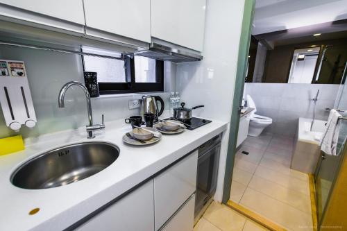 a kitchen counter with a sink and a toilet at 謙匯國際酒店式公寓 CH Service Apartment in Taipei