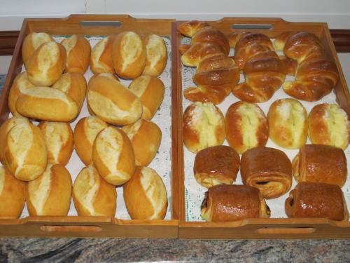 Dos bandejas de madera llenas de diferentes tipos de pan. en Hotel La Lanzada, en A Lanzada