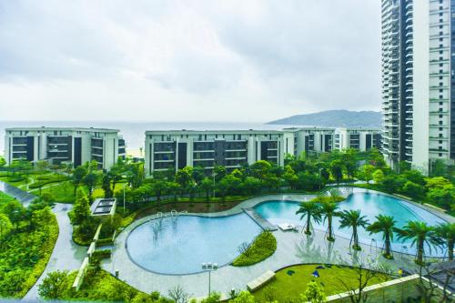 an overhead view of a large swimming pool in front of buildings at HuiZhou HuaYangNian Seaview Guesthouse in Huidong