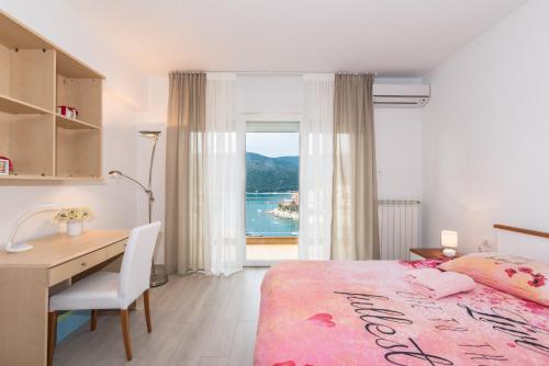 a bedroom with a desk and a bed and a window at Allegro in Rabac