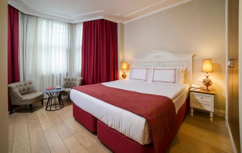 ein Hotelzimmer mit einem großen Bett und roten Vorhängen in der Unterkunft Amofta Hotel Taksim in Istanbul