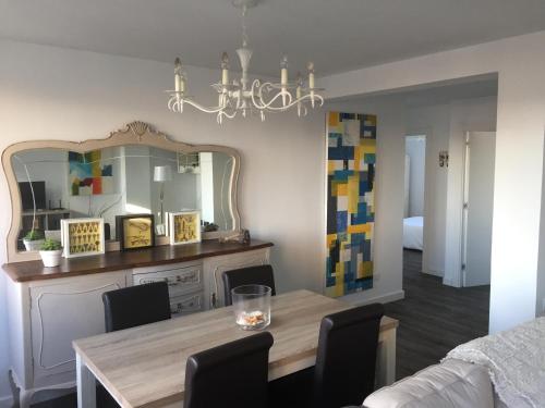 a dining room with a table and a mirror at Apartamento Turístico Alfredo Truan in Gijón