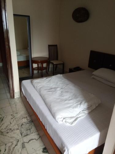 a bedroom with a bed and a table and a chair at Service Apartments, Park Street, Calcutta in Kolkata
