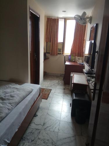 a bedroom with a bed and a desk and a couch at Service Apartments, Park Street, Calcutta in Kolkata