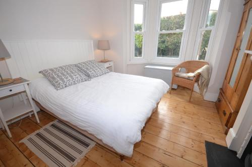 a bedroom with a white bed and two windows at 20 Bellevue Road in Ryde
