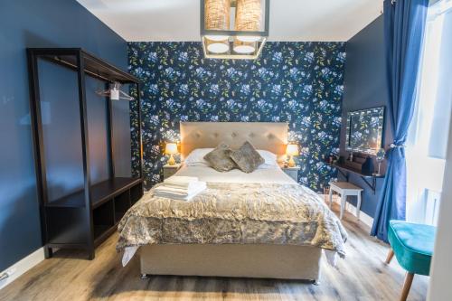 a bedroom with a bed and a blue wall at The Torfin in Edinburgh