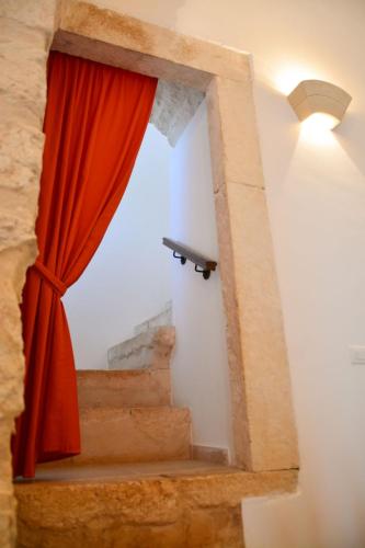 a window with a red curtain next to a staircase at Torre Bruno in Carpino