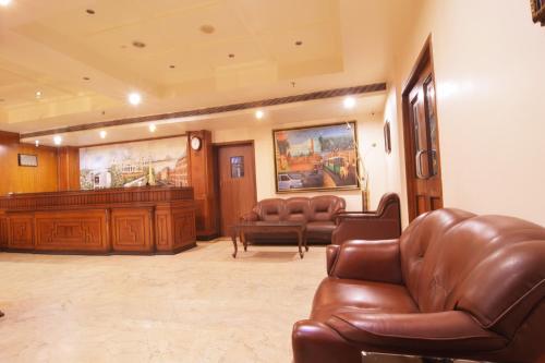 a waiting room with leather chairs and a courtroom at Hotel The Sojourn in Kolkata