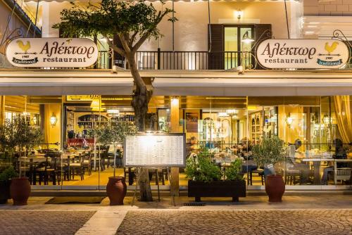 a restaurant with tables and chairs in front of a building at Alektor Luxury Apartments in Zakynthos Town