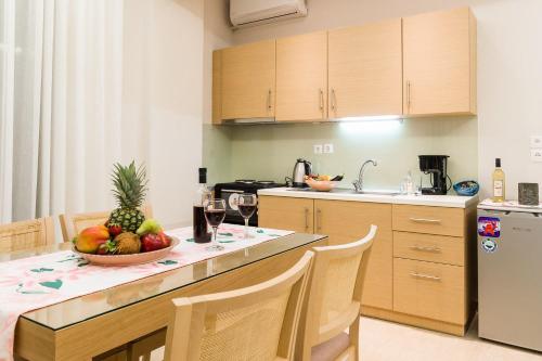 a kitchen with a table with a bowl of fruit on it at Alektor Luxury Apartments in Zakynthos Town