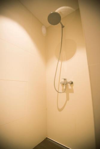 a bathroom with a shower with a light on the wall at Gastenkamers UitGaanSlapen in Nieuwpoort