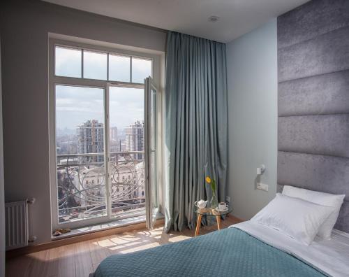 a bedroom with a bed and a large window at Apartments Belietazh in Odesa