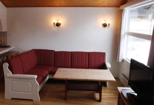 - un salon avec un canapé rouge et une table dans l'établissement Eventyrlige Skaret, à Årøy