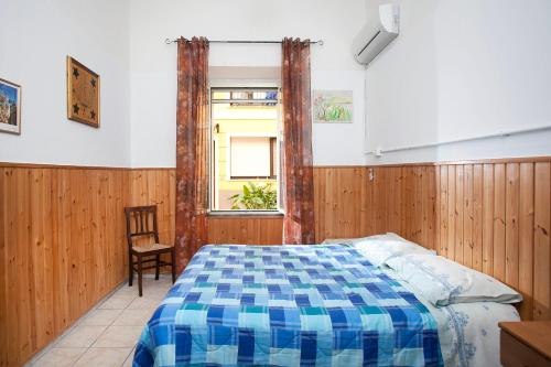 ein Schlafzimmer mit einem Bett, einem Stuhl und einem Fenster in der Unterkunft Davi in Cagliari