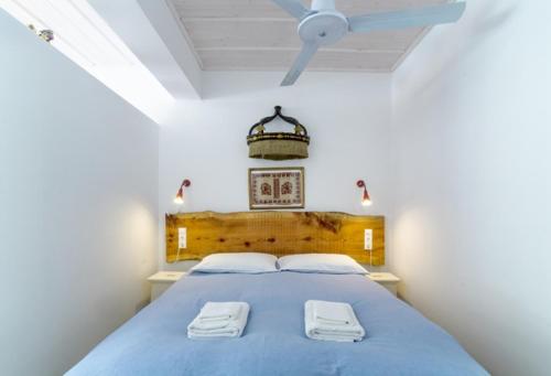 um quarto com uma cama azul com duas toalhas em Relax in a natural park em Lerápetra