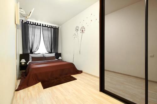 a bedroom with a bed and a large mirror at PaulMarie Apartments on Karpovicha in Gomel