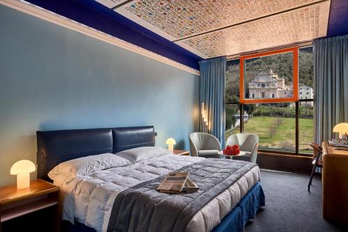 a bedroom with a bed and a large window at Albornoz Palace Hotel in Spoleto