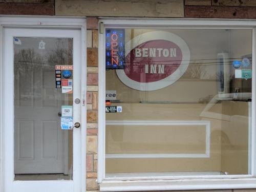 a front door of a store with a sign on the window at Benton Inn in Benton