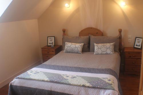 une chambre avec un grand lit et deux tables de nuit dans l'établissement Walnut House, à Vire