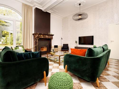 sala de estar con 2 sofás verdes y chimenea en Opulent Holiday Home in Spa with Sauna, en Spa