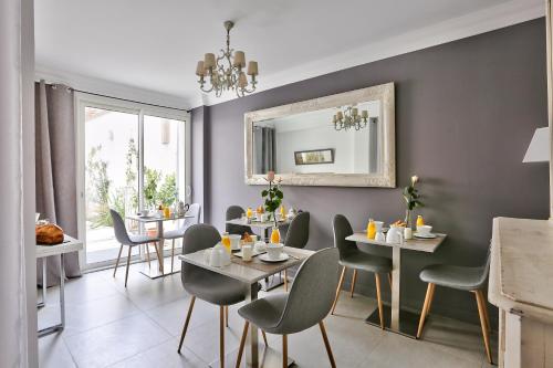 - une salle à manger avec des tables, des chaises et un miroir dans l'établissement Le clos de l'olivier, à Paris