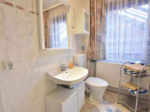 a bathroom with a sink and a toilet and a window at Beautiful Apartment in Proseken with Garden in Proseken