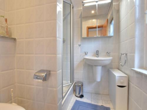 La salle de bains est pourvue d'un lavabo, de toilettes et d'une douche. dans l'établissement Attractive Bungalow in Damshagen near the Sea, à Damshagen