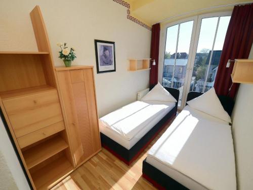 キュールングスボルンにあるQuaint Apartment in Kuhlungsborn by the Seaのベッド2台と窓が備わる小さな客室です。
