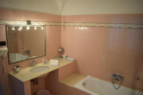 a bathroom with a sink and a tub and a mirror at Palazzo Tucci Residenza d'epoca in Lucca