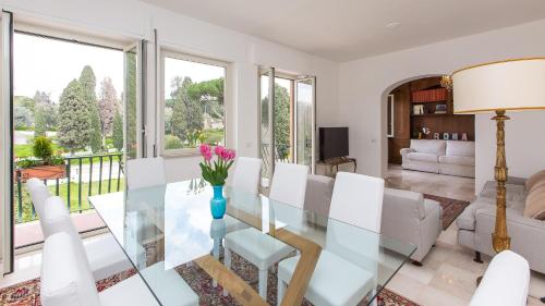 a dining room with a glass table and white chairs at Rental in Rome Colosseo View Luxury in Rome