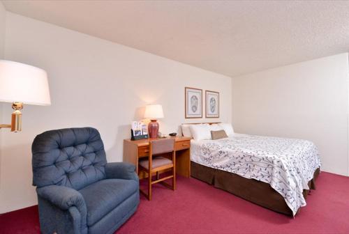 - une chambre avec un lit, une chaise et un bureau dans l'établissement America's Best Value Inn & Suites International Falls, à International Falls