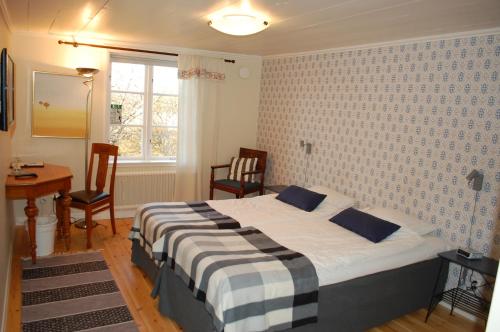 a bedroom with a bed and a table and chairs at Allégården Kastlösa Hotell in Kastlösa