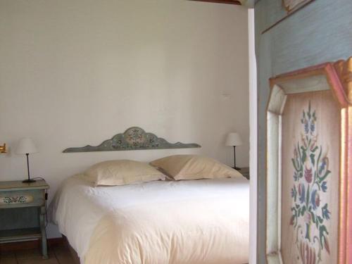 un letto bianco in una camera bianca con due lampade di Cozy chalet with dishwasher, in the High Vosges a Le Ménil