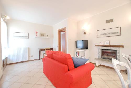 a living room with a red couch and a fireplace at La casa dei Sogni in Stresa