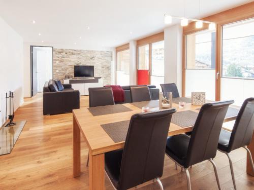 a dining room and living room with a table and chairs at Chalet Nepomuk in Zermatt