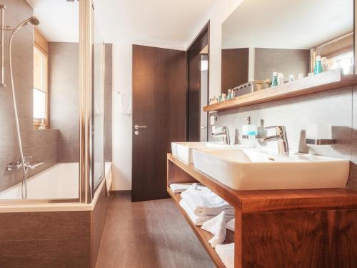 a bathroom with two sinks and a shower at Chalet Nepomuk in Zermatt