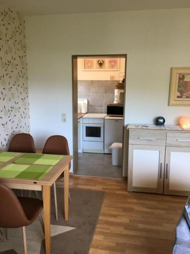 ゲロルシュタインにあるFerienhaus Munterleyのキッチン(テーブル付)、キッチン(白い家電製品付)