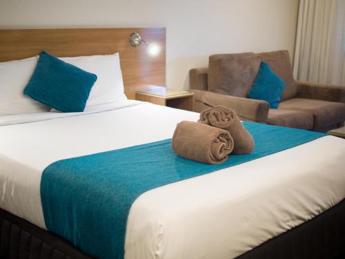 um quarto de hotel com uma cama com toalhas em Sunnybank Star Hotel em Brisbane
