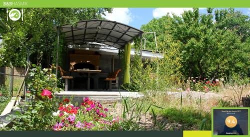a kiosk in a garden with flowers at Guest house Hasmik in Yeghegnadzor